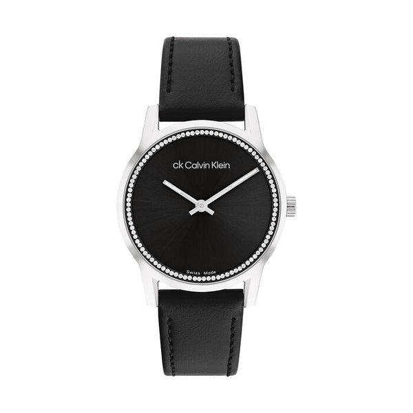 Calvin Klein Women’s Dressed Watch, 32mm stainless steel case, black sunray dial, crystal-set bezel, silver-tone hands, minimalist design, black leather strap, Swiss-made quartz movement.