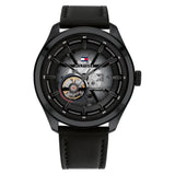 A Tommy Hilfiger men's automatic watch with a 45mm round black stainless steel case and a black leather strap. The watch features a semi-transparent black dial that reveals part of the inner mechanical movement. It includes a visible open-heart complication at the 9 o'clock position, silver-tone hands, and a detailed outer minute track. The Tommy Hilfiger flag logo is placed near the 12 o’clock mark, with the word “AUTOMATIC” printed on the right side of the dial. The design is bold, modern, and mechanical 